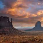 Sunset over Monument Valley transforms The Mittens into glowing silhouettes — a timeless symbol of the American Southwest. regional back roads and byways. travel guides. vacationers vs travelers