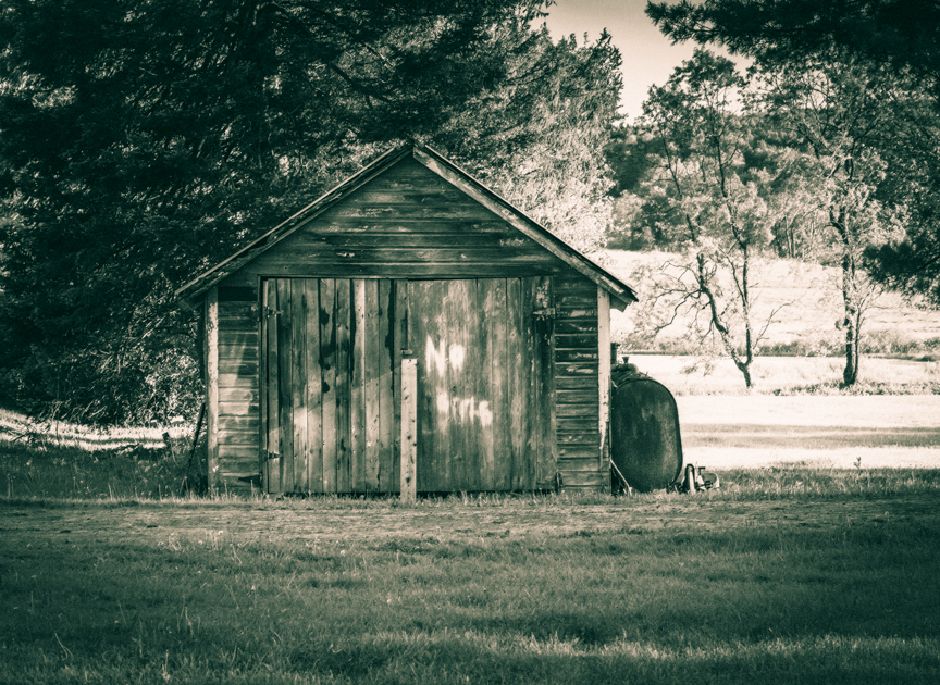 Large wooden clubhouse resembling a shed with a hand-painted “No Girls” sign on the door.