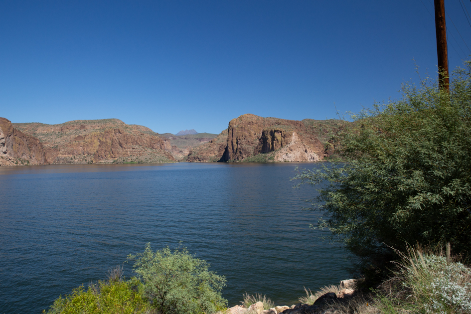 Apache Lake reflecting desert cliffs under the Arizona sun.