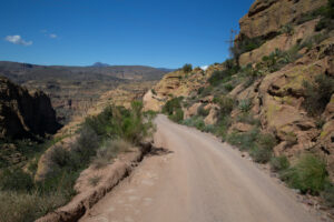 Dusty dirt road climbing through the foothills of the Superstition Mountains.