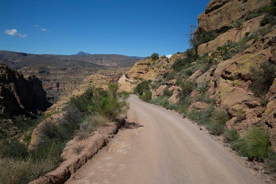 Dusty dirt road climbing through the foothills of the Superstition Mountains.
