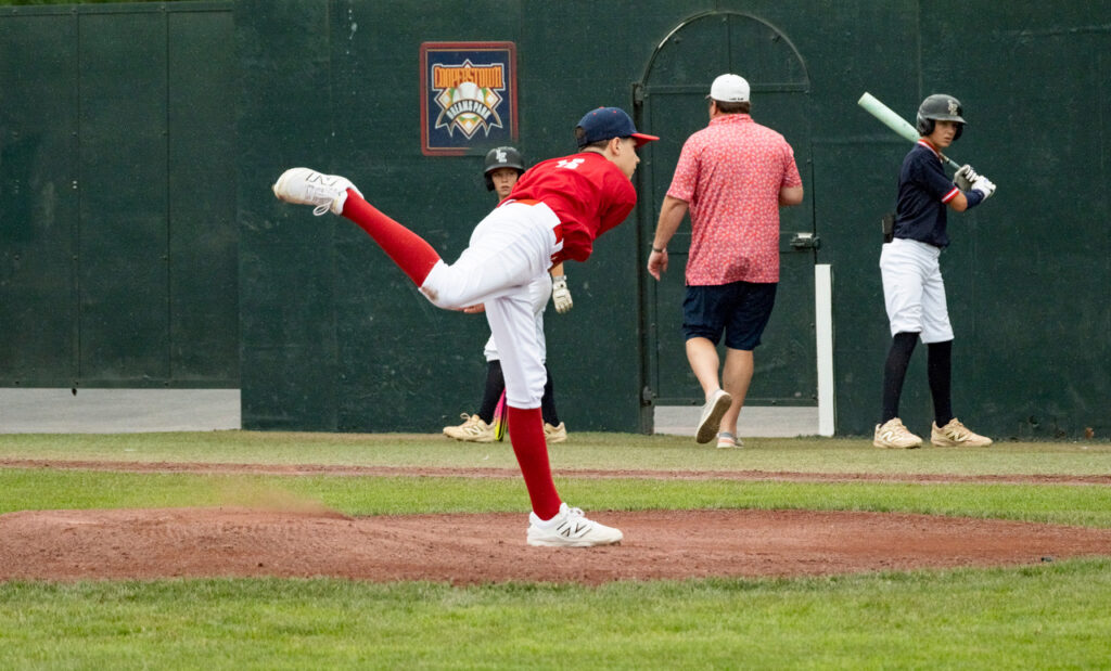 Youth baseball pitcher following through after releasing the ball at Cooperstown Dreams Park.
