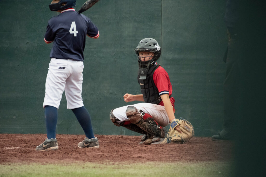Youth baseball catcher looking toward the coach for a sign during a game at Cooperstown Dreams Park.