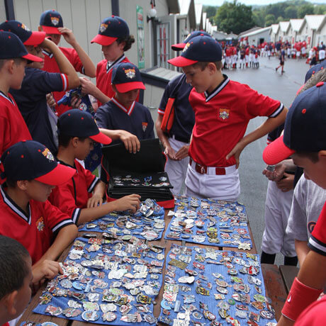 Youth baseball players trading team pins at Cooperstown Dreams Park.